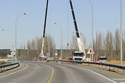 Dos grúas en el puente del Duero en la variante de Almazán depositaban placas de hormigón para el firme de la A-15 a su paso por esta zona. / VALENTÍN GUISANDE-