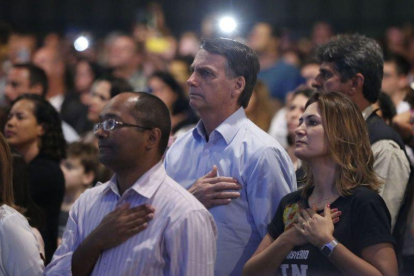 El presidente electo de Brasil  Jair Bolsonaro  y su esposa Michelle Bolsonaro  mientras participan en un culto evangelico.-FERNANDO FRAZAO (EFE)