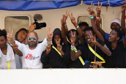 Inmigrantes y miembros de la tripulación del Aquarius celebran su llegada al puerto de La Valeta.-DARRIN ZAMMIT LUPI (REUTERS)