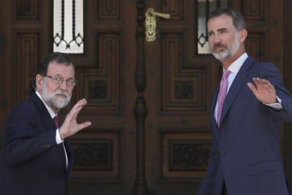 Mariano Rajoy y Felipe VI saludan a la prensa antes de entrar en el Palacio de Marivent para el almuerzo de trabajo.-EFE / BALLESTEROS