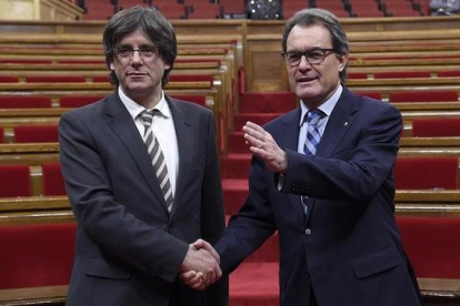 El nuevo presidente de la Generalitat Carles Puigdemont junto a Artur Mas.-AFP / LLUIS GENE