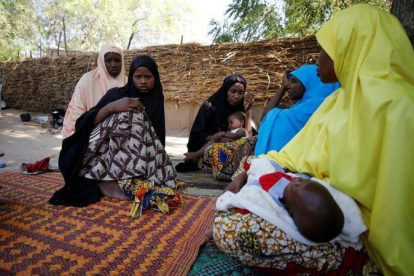 Familiares consuelan a la madre de una de las 110 niñas desaparecidas tras el ataque de Boko Haram a una escuela de Dapchi, en Nigeria.-AFOLABI SOTUNDE (REUTERS)