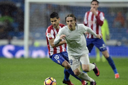 Luka Modric se va de Nacho Cases durante el partido contra el Sporting del sábado pasado en el Bernabéu.-AFP / JAVIER SORIANO