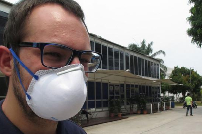 Un trabajador del  Dorna, organizadora del Mundial de motociclismo, con una mascarilla para protegerse de la nube tóxica que flota sobre Malasia.-EMILIO PÉREZ DE ROZAS