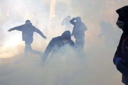 Jóvenes encapuchados lanzan cóctels molotov en la manifestación del Primero de Mayo en París.-AP / THIBAULT CAMUS