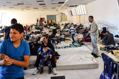 Un grupo de inmigrantes, la mayoría refugiados sirios, en un pabellón deportivo en la isla de Creta.-Foto: AFP / IASON TAVLAS