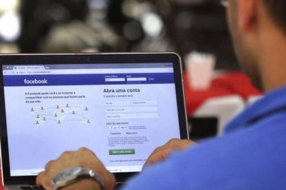 Un hombre entra en su página de Facebook en un restaurante en Brasilia.-ERALDO PERES (AP)