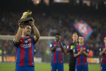 Luis Suárez exhibe el Balón de Oro conquistado de la temporada 2015-16 a la hinchada del Barça en el Camp Nou.-JORDI COTRINA