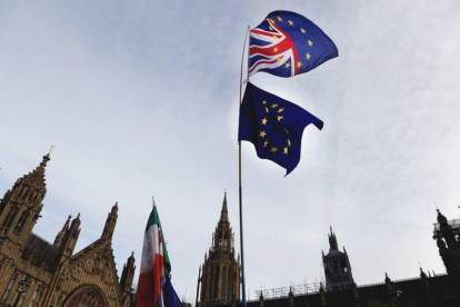 Un manifestante sostiene las bandera de Gran Bretaña y de la UE en una protesta ante el Parlamento británico, en Londres.-FRANK AUGSTEIN (AP)