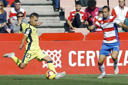Fran Villalba en el momento de golpear el balón ante la presencia del jugador del Granada Víctor Díaz.-Área 11