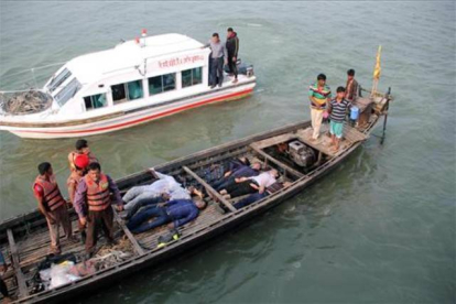 Los equipos de emergencia, rescatan a pasajeros del ferri, tras la colisión, este domingo, en el río Padma, en Bangladesh.-Foto: AFP