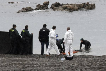 Agentes de la Guardia Civil retiran el cuerpo del subsahariano encontrado hoy en la playa del Tarajal de Ceuta.-Foto:   EFE / REDUAN DRIS REGRAGUI
