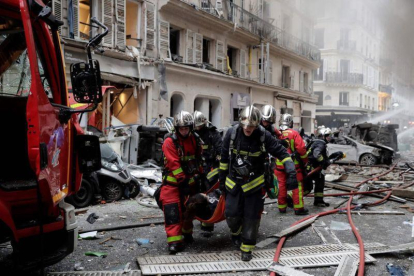 Los bomberos trasladan a una herida en la explosión en una panadería en París, este sábado.-AFP