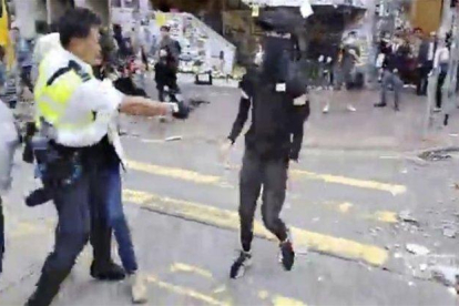 Un policía en Hong Kong dispara contra los manifestantes.-AP