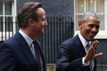 Cameron (izquierda) y Obama caminan sonrientes por el exterior de Downing Street, este viernes.-AFP / JUSTIN TALLIS