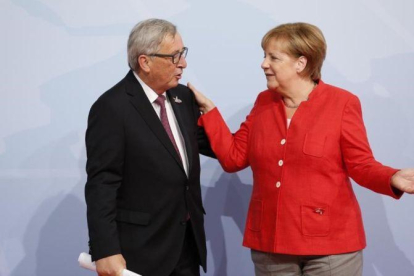 Jean Claude Juncker y Angela Merkel, en la cumbre del G-20 del pasado mes de julio en Hamburgo.-FRIEDEMANN VOGEL POOL