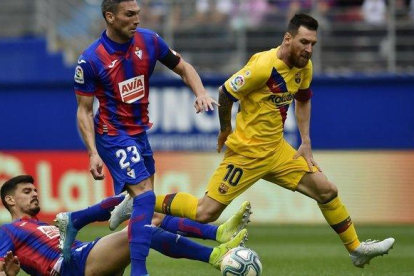 Messi desborda a dos jugadores del Eibar en el partido del sábado.-ÁLVARO BARRIENTOS (AP)