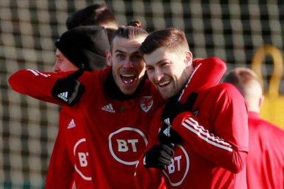 El madridista Gareth Bale (i) se abraza con Ben Davis en un entrenamiento de Gales de esta semana.-