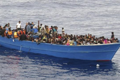 Un grupo de inmigrantes en una embarcación precaria a la espera de ser rescatados en el Mediterráneo, el 28 de octubre del 2015.-EFE