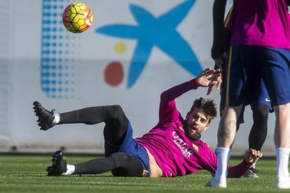 Piqué persigue el balón en el rondo durante el entrenamiento del Barça previo al duelo contra el Granada.-JORDI COTRINA