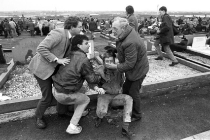 McGuinness, en 1988, ayuda a un herido en un atentado durante el funeral de un miembro del IRA.-DAVID JONES / AP