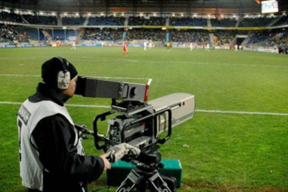 Un cámara de una cadena de televisión toma imágenes durante un partido de fútbol.-ARCHIVO