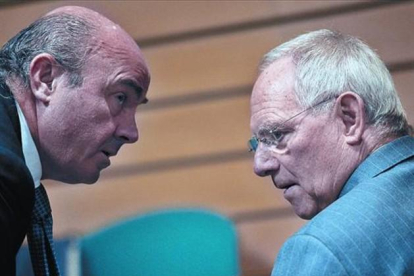 Guindos, con su homólogo alemán Wolfgang Schauble, en una reunión del Ecofin en Bruselas.-AFP PHOTO / GEORGES GOBET