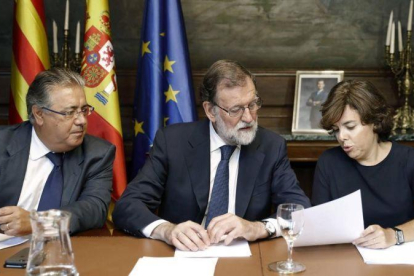 El presidente del Gobierno  Mariano Rajoy , junto al ministro del Interior  Juan Ignacio Zoido  y la vicepresidenta Soraya Saenz de Santamaria.-ANDREU DALMAU/EFE