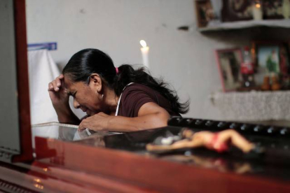 Una mujer llora sobre el féretro de Miguel Ángel Jiménez, este domingo en Xaltianguis.-AFP
