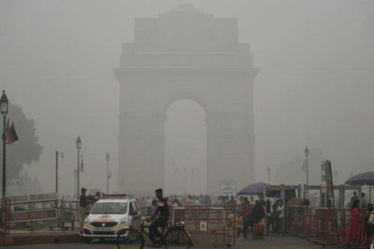 Turistas visitan la Puerta de la India bajo una fuerte niebla de polución en Nueva Deli.-SAJJAD HUSSAIN (AFP)