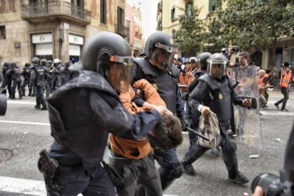 Dos policías con uno de los manifestantes detenidos en Vía Laietana.-MANU MITRU
