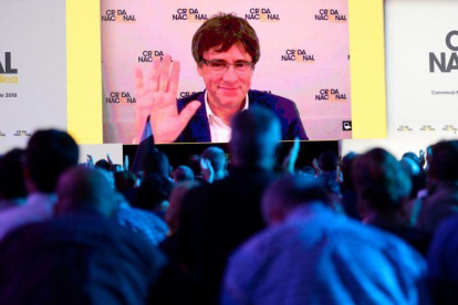 Puigdemont saluda desde la gran pantalla del acto fundacional de la Crida que se ha celebrado este sábado en el pabellón Nou Congost de Manresa.-AFP