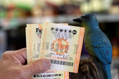 Un hombre muestra sus billetes de lotería Powerball en la tienda de licor Bluebird el 22 de agosto de 2017, en Hawthorne, California (EE.UU.).-EFE