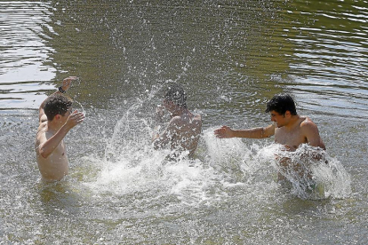 Jóvenes refrescándose durante la ola de calor en la Playa de las Moreras de Valladolid-J. M. LOSTAU
