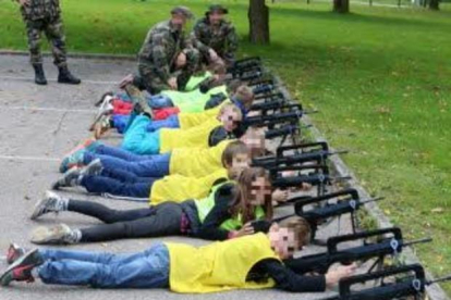 Los niños tirados en el suelo con fusiles de asalto.-