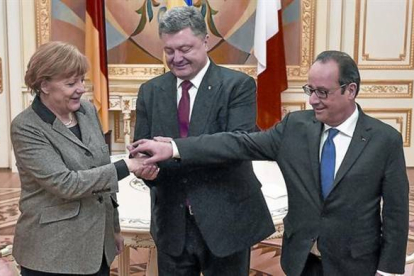 Merkel y Hollande, con el presidente ucraniano, Petró Poroshenko (en el centro), justo antes del inicio de la reunión, ayer, en Kiev.-Foto: REUTERS