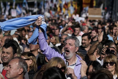 Un hombre empuña la bandera argentina entre la multitud que ha tomado las calles de Buenos Aires para protestar por la situación económica del país.-VICTOR R. CAIVANO (AP)