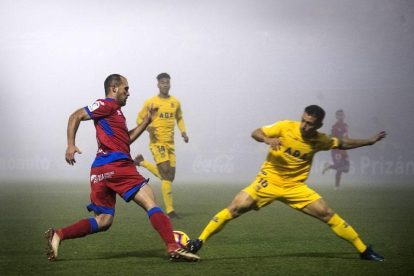 Unai Medina recibe la entrada de Bellvís en un momento del partido disputado el domingo entre Numancia y Alcorcón y bajo una densa niebla.-ÁREA 11