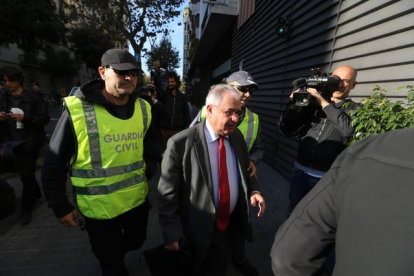 El tesorero de CDC, Andreu Viloca, a su entrada en la sede del partido, escotado por agentes de la Guardia Civil.-DANNY CAMINAL