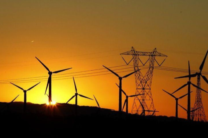 Torre eléctrica y molinos de energía eólica.-LUCY NICHOLSON (REUTERS)