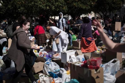 Un grupo de voluntarios reúne las bolsas y cajas que han traído vecinos de Atenas para los refugiados.-AFP / ANGELOS TZORTZINIS