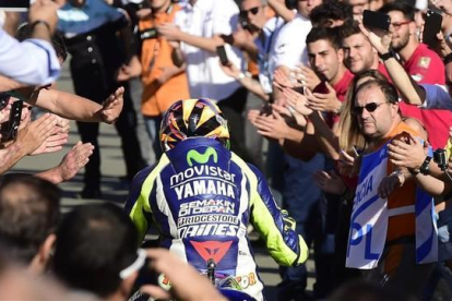 Valentino Rossi se dirige a su box entre aplausos de los aficionados tras acabar cuarto en el GP de la Comunitat Valenciana.-AFP / JOSÉ JORDÁN