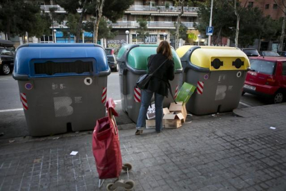 Una mujer deposita residuos en contenedores.-ARCHIVO