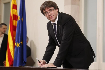 El president Carles Puigdemont en el momento de firmar la declaración, tras el pleno.-JULIO CARBÓ