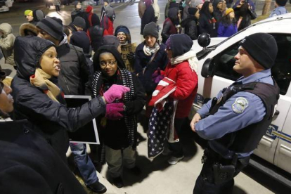 Una manifestante se encara con un policía, ante la comisaría de Ferguson, anoche, tras conocerse la decisión del Departamento de Justicia.-Foto:   AP / CHARLES REX ARBOGAST