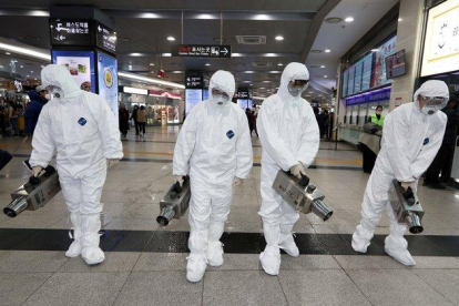 écnicos rocían desinfectante como parte de los esfuerzos para prevenir la propagación de un nuevo virus que se originó en la ciudad china de Wuhan, en una terminal de autobuses en Gwangju, el 28 de enero del 2020.-AFP