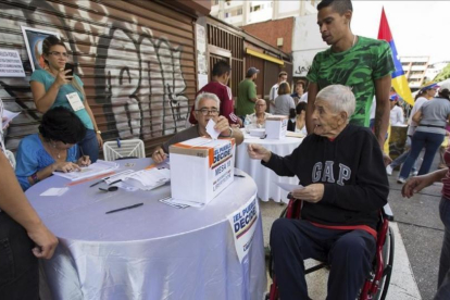 Un grupo de personas participa en la votación de la oposición en Caracas.-EFE / NATHALIE SAYAGO