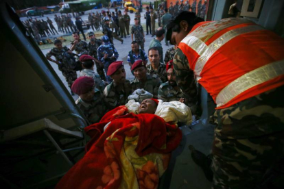 Soldados nepalíes fueron registrados este martes al trasladar a un herido, tras un terremoto de 7,3 grados en la escala Richter, en el aeropuerto de Katmandú (Nepal).-Foto: EFE