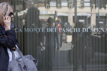 Una mujer pasa ante una oficina del banco Monte Dei Paschi Di Siena en Roma.-ARCHIVO / AP (AP)