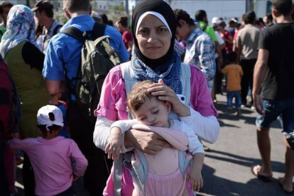Una refugiada siria con su hija tras llegar a Grecia.-AFP / LOUISA GOULIAMAKI